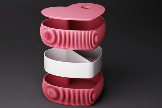 A heart-shaped ribbed storage container shown in an exploded stack view with a pink lid, pink outer compartments, and a white middle band, on a light gray background.